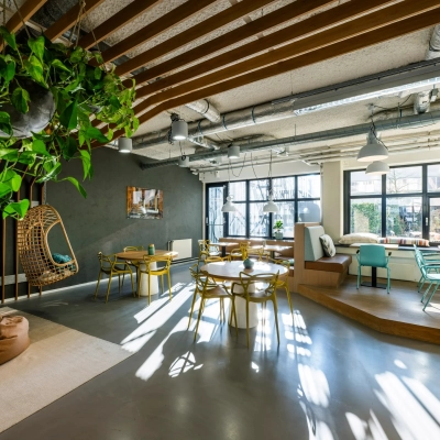 Lichte kantoorruimte met houten details en planten aan het plafond, gelegen op Westblaak 180 in Rotterdam Centrum, ideaal voor wie een kantoor wil huren. Verschillende zitopties beschikbaar.