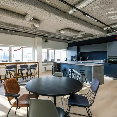 Moderne kantoorruimte te huur op Westblaak 180, Rotterdam Centrum, met open keuken en zitgedeelte, veel daglicht en stijlvolle meubels.