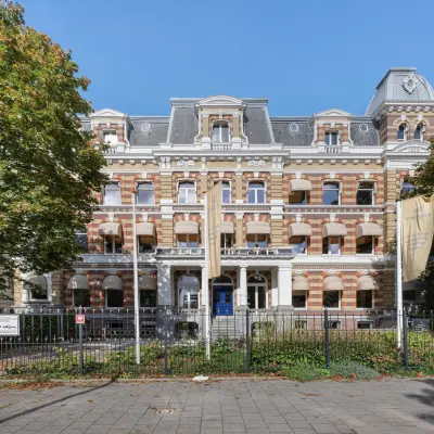 Historisch kantoorpand op Westplein 12 in Rotterdam Centrum, omringd door hoge bomen.