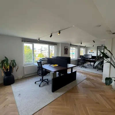Moderne kantoorruimte te huur op Westplein 12 in Rotterdam Centrum met grote ramen, bureaus en stoelen op houten vloer.