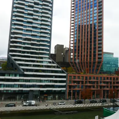 Uitzicht op moderne kantoorpanden aan Wijnhaven 76 in Rotterdam Centrum met opvallende architectuur en omliggende omgeving. Geschikt voor kantoorruimte huren nabij het water.