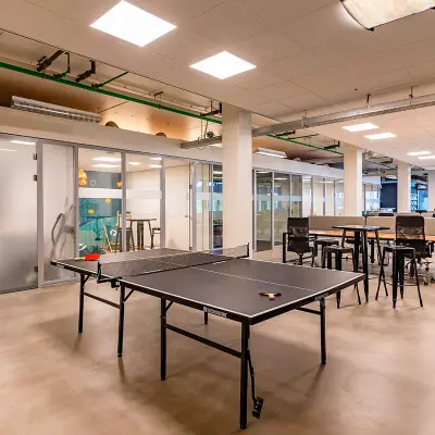 Moderne kantoorruimte op Kratonkade 7-27 in Rotterdam Delfshaven, met werkplekken, glazen wanden en een tafeltennistafel, ideaal voor kantoorruimte huren.