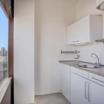 Compacte pantry in lichte kantoorruimte met uitzicht, ideaal voor kleine pauzes. Voorzien van een aanrecht en opbergruimte. Gelegen aan de Kratonkade in Rotterdam Delfshaven.