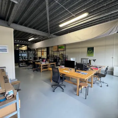 Kantoorruimte op Van Helmontstraat 17-23 in Rotterdam Delfshaven, lichte werkplekken met bureau en stoelen. Ideaal voor het huren van een kantoorpand. Tafels zijn ingericht met computerschermen en kantoorbenodigdheden.