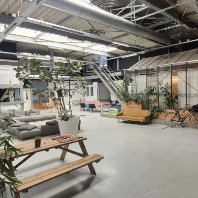Industrieel kantoorpand aan Van Helmontstraat 17-23 in Rotterdam Delfshaven met moderne werkplekken en veel planten. Ideaal om kantoorruimte te huren voor creatieve projecten.