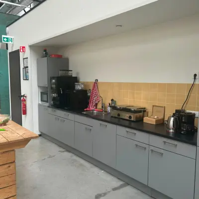 Een strak ingerichte pantry bij een kantoorpand op Scheepsbouwweg 29, Rotterdam Waalhaven. Deze kantoorruimte huren biedt moderne voorzieningen met een keurige koffiemachine en aanrecht. Ideaal voor ontspannen pauzes tijdens je werkdag.
