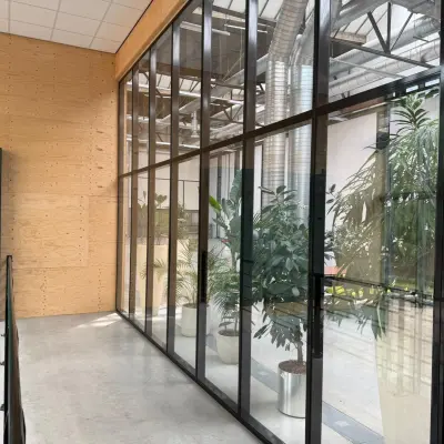 Moderne kantoorruimte huren aan Scheepsbouwweg 29, Rotterdam Waalhaven met glazen wanden, planten en betonnen vloer.