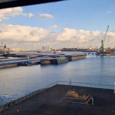 Uitzicht vanuit een kantoor op Waalhaven Zuidzijde 21, Rotterdam, met een panoramisch zicht op de haven met kranen en schepen.