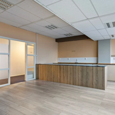 Interieur van een leeg kantoor op de Brauwweg 52-66, Schiedam, met lichte muren, houten vloer en ingebouwde kast; kantoorruimte huren mogelijk.