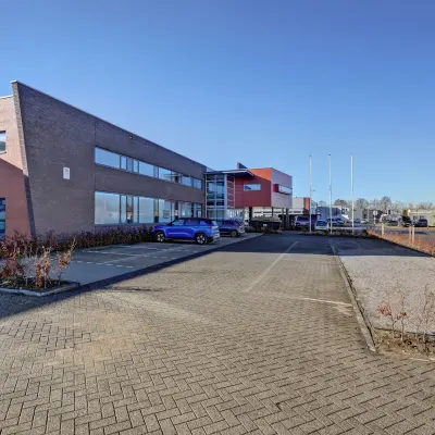Exterieur van kantoorpand op Fischerpad 106 in Sittard, met een ruime parkeerplaats en moderne architectuur. Ideaal voor kantoorruimte huren.
