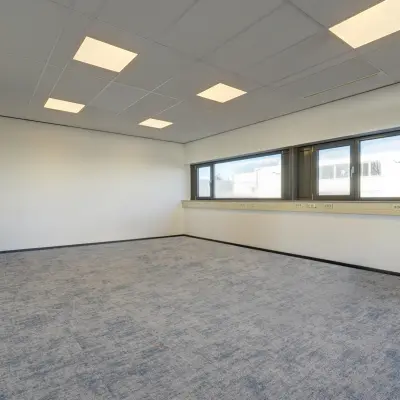 Lichte en ruime kantoorruimte te huur op Fischerpad 106, Sittard. Grote ramen bieden veel natuurlijk licht, ideaal voor diverse kantooropstellingen. Neutrale vloer en plafondverlichting complementeren de strakke uitstraling.