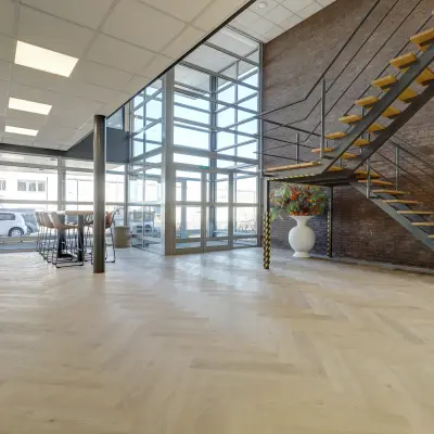 Moderne kantooringang op Fischerpad 106, Sittard, met een open trap en glaswanden. Geschikt voor wie kantoorruimte wil huren in een stijlvol kantoorpand.