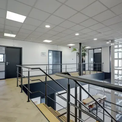 Moderne kantoorruimte met zicht op trap en glazen wanden, ideaal voor wie kantoorruimte wil huren in Sittard.