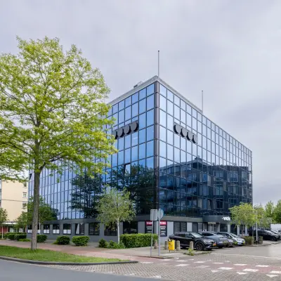 Modern kantoorpand aan de Curieweg 9 in Spijkenisse met een strakke glazen gevel en parkeermogelijkheden, ideaal voor wie kantoorruimte wil huren.