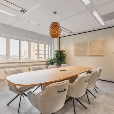 Moderne vergaderruimte in het kantoorpand aan Leidseveer 2-10 nabij Utrecht Centraal Station. De ruimte heeft een grote tafel met comfortabele stoelen en decoratieve elementen. Ideaal voor kantoorruimte huren.