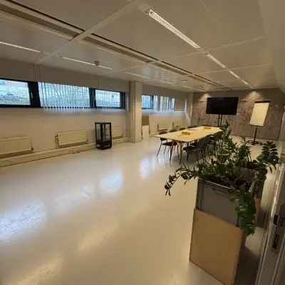 Kantoorruimte op Bernadottelaan 13 in Utrecht Kanaleneiland met grote tafel en stoelen, geschikt voor vergaderingen of werkruimtes huren.
