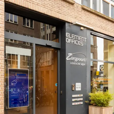 Exterieur van een kantoorpand aan Middenburcht 136 in Utrecht Leidsche Rijn. Het pand heeft een moderne glazen ingang en een bord met bedrijfsnamen naast de deur.