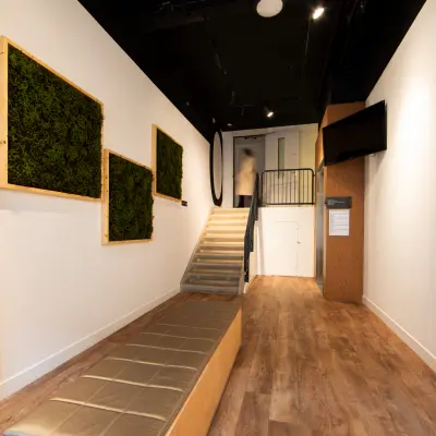 Ingang van een kantoorpand op Middenburcht 136, Utrecht Leidsche Rijn met houten vloer, trap en moderne muurdecoratie. Zakelijke sfeer bij het huren van kantoorruimte in dit gebouw.