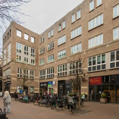 Bakstenen kantoorpand op Middenburcht 136 in Utrecht Leidsche Rijn met fietsenstalling en verschillende winkels op de begane grond. Ideale locatie voor kantoorruimte huren.