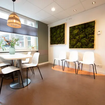 Lichte kantoorruimte in Utrecht Leidsche Rijn met ronde tafel en stoelen, kunst aan de muur en veel daglicht. Ideaal om te huren als vergaderruimte.