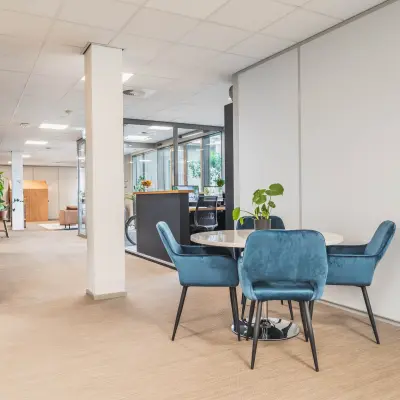 Kantoorruimte huren in Utrecht Papendorp met een open vloerplan. Het kantoorpand heeft een moderne inrichting met comfortabele blauwe stoelen rondom een tafel.