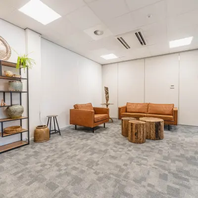 Gezellige kantoorruimte huren in Utrecht Papendorp met zitgedeelte, leren banken en houten tafels op Orteliuslaan 850. Moderne inrichting met decoraties en planten.