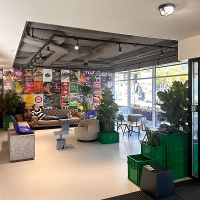 Moderne ontvangstruimte in een kantoorpand met kleurrijke muurposters, planten en comfortabele zitgelegenheid op Daltonlaan 200, Utrecht Rijnsweerd. Ideaal voor kantoorruimte huren.