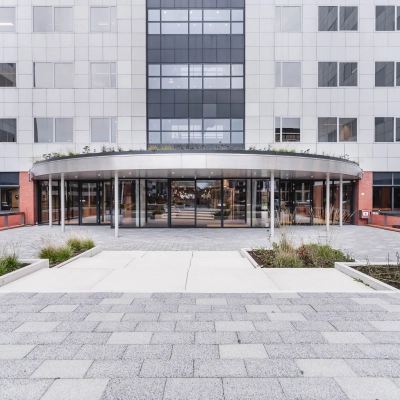 Vooraanzicht van het moderne kantoorpand op Varrolaan 100-126 in Utrecht Rijnsweerd met ruime entree en glazen deuren.