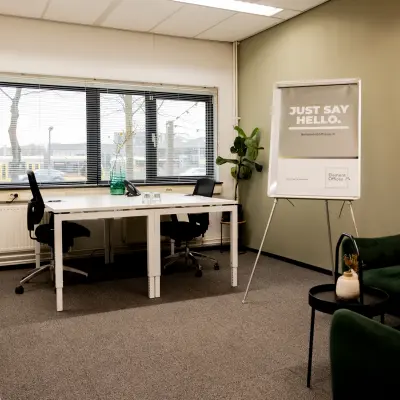 Gemeubileerde kantoorruimte te huur op Winthontlaan 200, Utrecht Zuid, met bureaus, stoelen, planten en een presentatiebord voor zakelijke activiteiten.