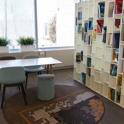 Moderne kantoorruimte op Kaldenkerkerweg 20 in Venlo met grote boekenwand, diverse stoelen en veel daglicht. Ideaal voor wie kantoorruimte wil huren voor creatieve brainstormsessies of als gezellige werkplek.