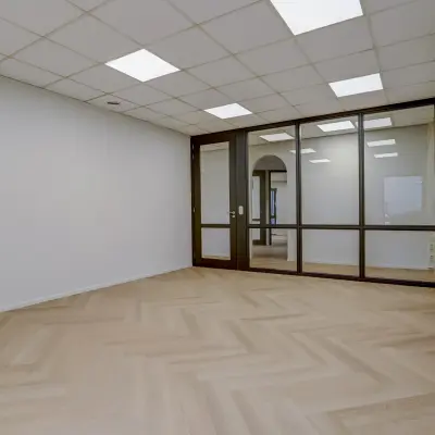 Leegstaande kantoorruimte te huur in Venray, Keizersveld 47, met houten vloer en glazen wanden.
