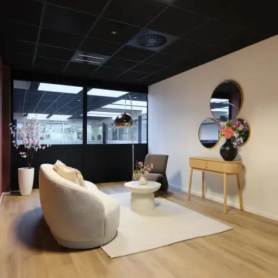 Modern ingerichte kantoorruimte op Havenweg 24, Vianen Utr, met stijlvolle zitgedeelte, sierlijke planten en decoratieve spiegels. Ideaal voor wie een kantoorpand wil huren.
