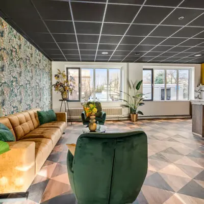 Lichte kantoorruimte in Wageningen met stijlvolle inrichting, inclusief bank, planten en marmeren aanrechtblad. Ideaal voor huren op Agro Business Park 22.