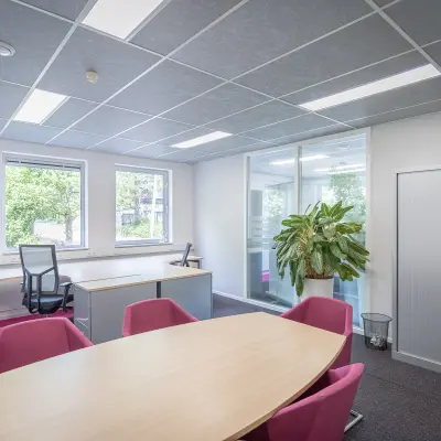 Verlichte kantoorruimte aan Molenweer 2 in Wateringen met grote tafel en stoelen, naast werkruimte aan het raam. Geschikt voor kantoorruimte huren in een functioneel kantoorpand.