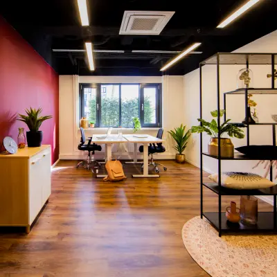 Moderne kantoorruimte huren op Pelmolenlaan 16 in Woerden, met warme houten vloer en decoratieve planten, perfect voor een inspirerende werkomgeving.