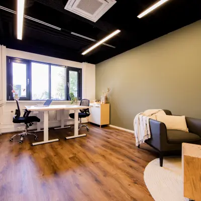 Moderne kantoorruimte huren met grote ramen en houten vloer op Pelmolenlaan 16 in Woerden, met een bureau en comfortabele stoel. Ideaal kantoorpand voor diverse zakelijke doeleinden.