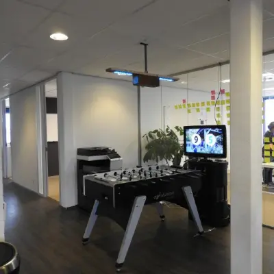 Moderne kantoorruimte te huur op Pompmolenlaan 9 in Woerden met tafelvoetbal en televisie, ideaal voor ontspanning en creatief werken.