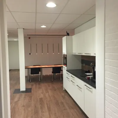 Kantoorruimte te huur in Woerden met een moderne keuken en een aangrenzende vergaderruimte. Ideaal voor bedrijven die kantoren zoeken met functionele voorzieningen.
