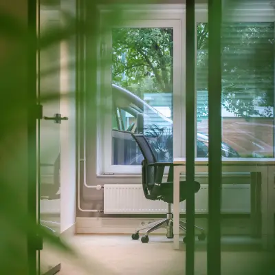 Kantoorruimte op Vijzelmolenlaan 9 in Woerden met een bureaustoel bij een bureau, zicht op bomen buiten.