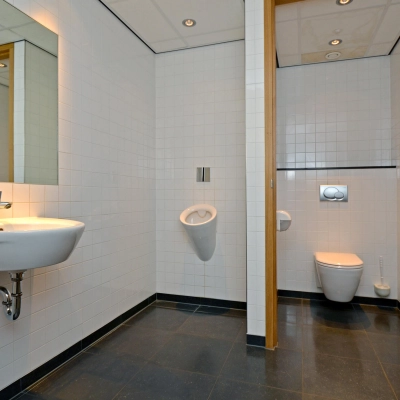 Interieurfoto van een badkamer in het kantoorpand op 1e Hogeweg 198, Zeist. Voorzien van een wastafel, toilet en urinoir, ideaal bij kantoorruimte huren.