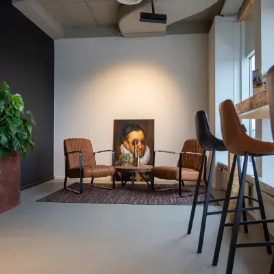Moderne kantoorruimte op Boerhaavelaan 40 in Zoetermeer met comfortabele stoelen en een opvallend schilderij. Ideaal voor creatieve inspiratie of vergaderingen.
