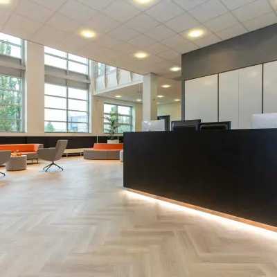 Ruime en lichte entree van een kantoorpand aan de Louis Braillelaan 80, Zoetermeer. Grote ramen verlichten de stijlvolle receptieruimte die uitnodigt tot kantoorruimte huren.