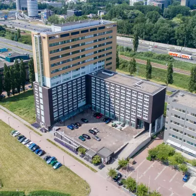Luchtfoto van het kantoorpand aan Louis Braillelaan 80 in Zoetermeer, omgeven door parkeerplaatsen en groen. Ideaal voor kantoorruimte huren.
