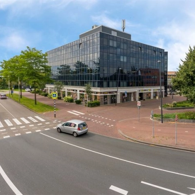 Modern kantoorpand op Stationsplein 4, Zwijndrecht, met grote glaspartijen en een stedelijke omgeving. Ideaal voor kantoorruimte huren dicht bij voorzieningen en openbaar vervoer.