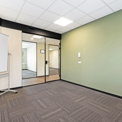 Leeg kantoorpand aan Stationsplein 4, Zwijndrecht, met modern interieur. Ideaal voor wie kantoorruimte wil huren. De ruimte heeft frisse groene accenten en voldoende licht.