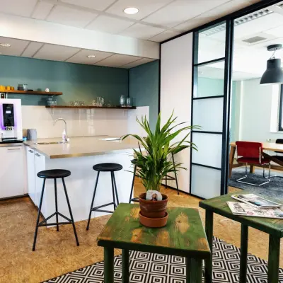 Moderne kantoorruimte huren op Hanzeplein 11-27 in Zwolle met een stijlvolle ingerichte pantry en aangrenzende werkplek met glazen deuren.